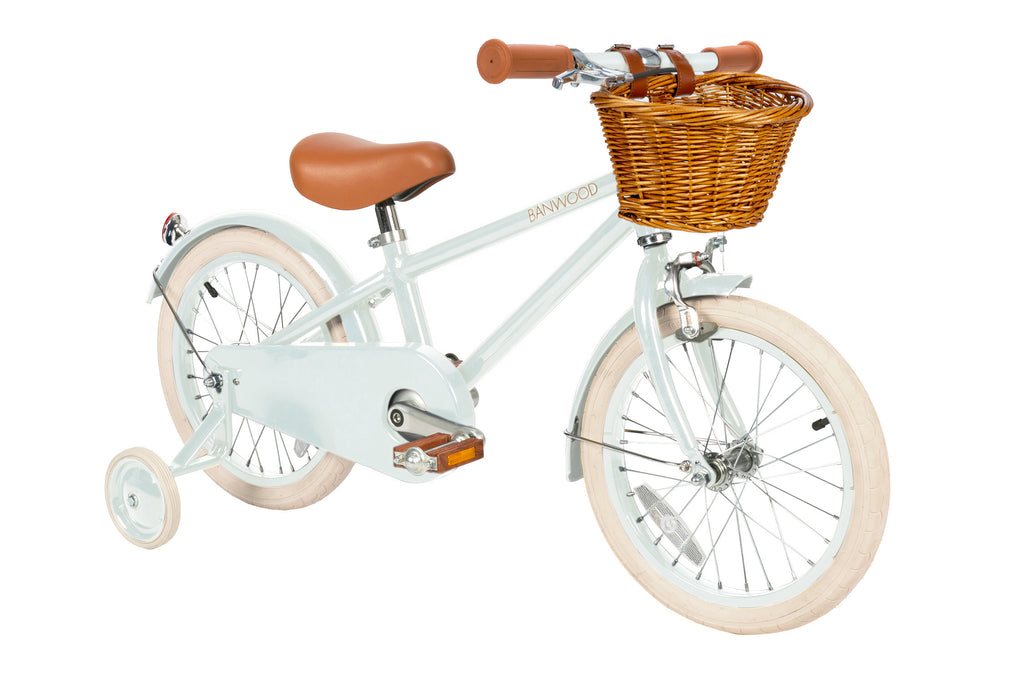 Children's bicycle with training wheels, mint frame, brown seat, and basket on a white background