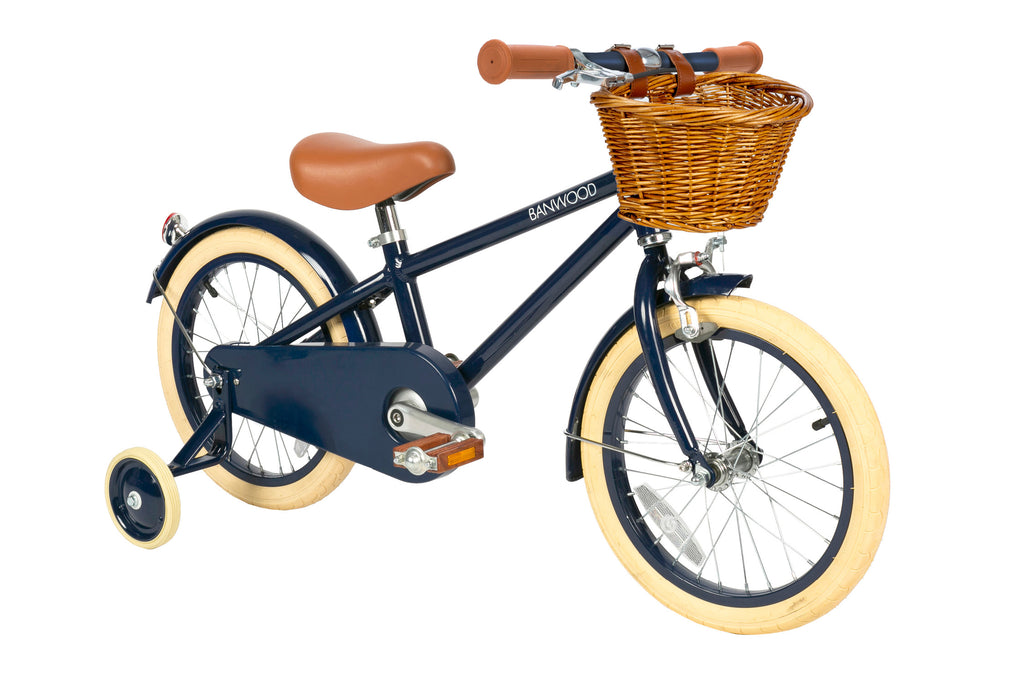 Children's bicycle with navy frame and a basket on a white background